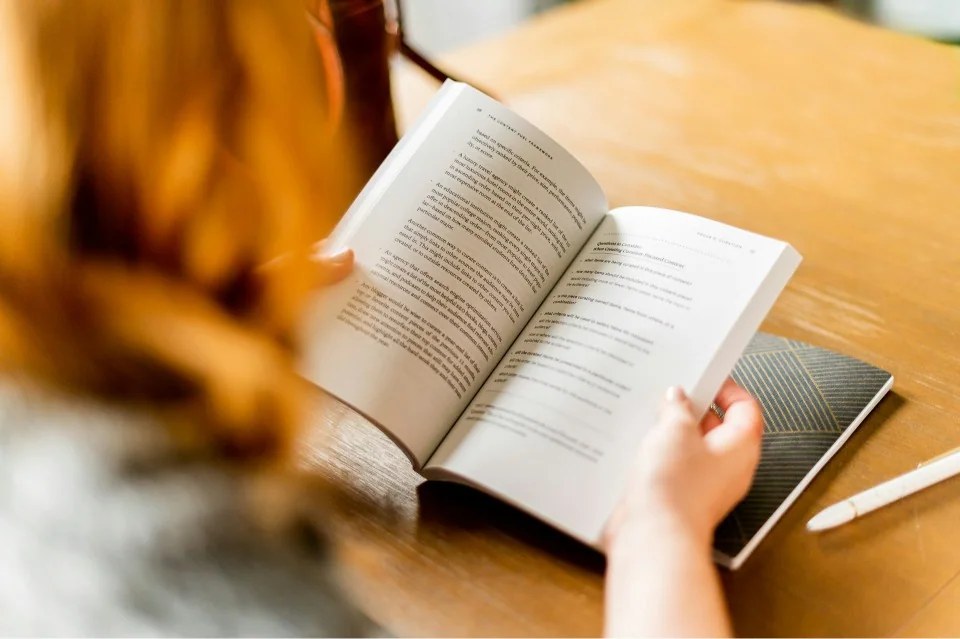 Customer reading a book at a table