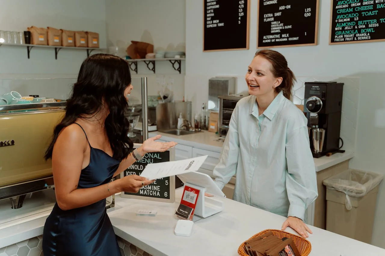 Cafe employee serving a customer at the counter