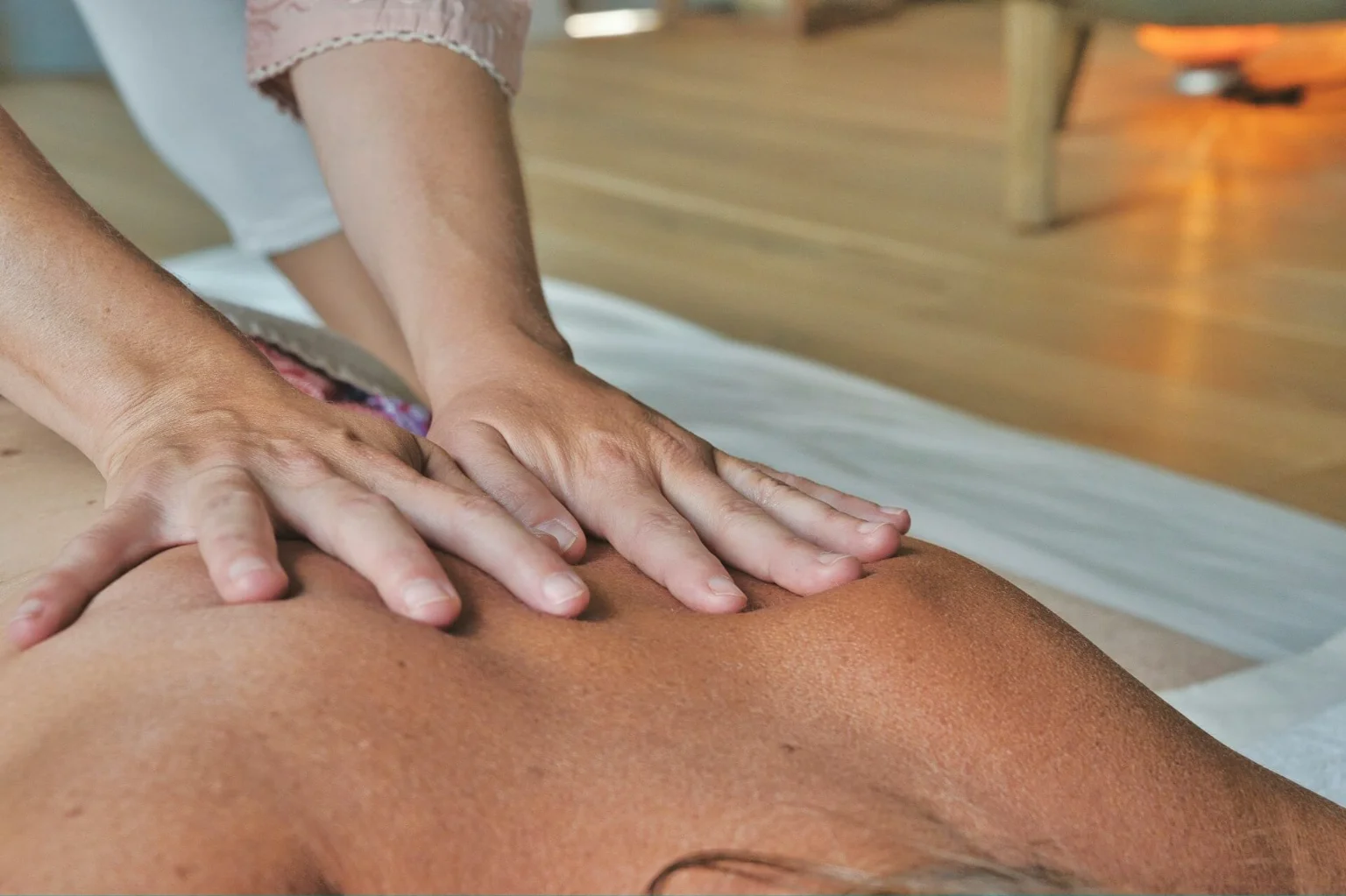 Massage therapist applying pressure to a client's back
