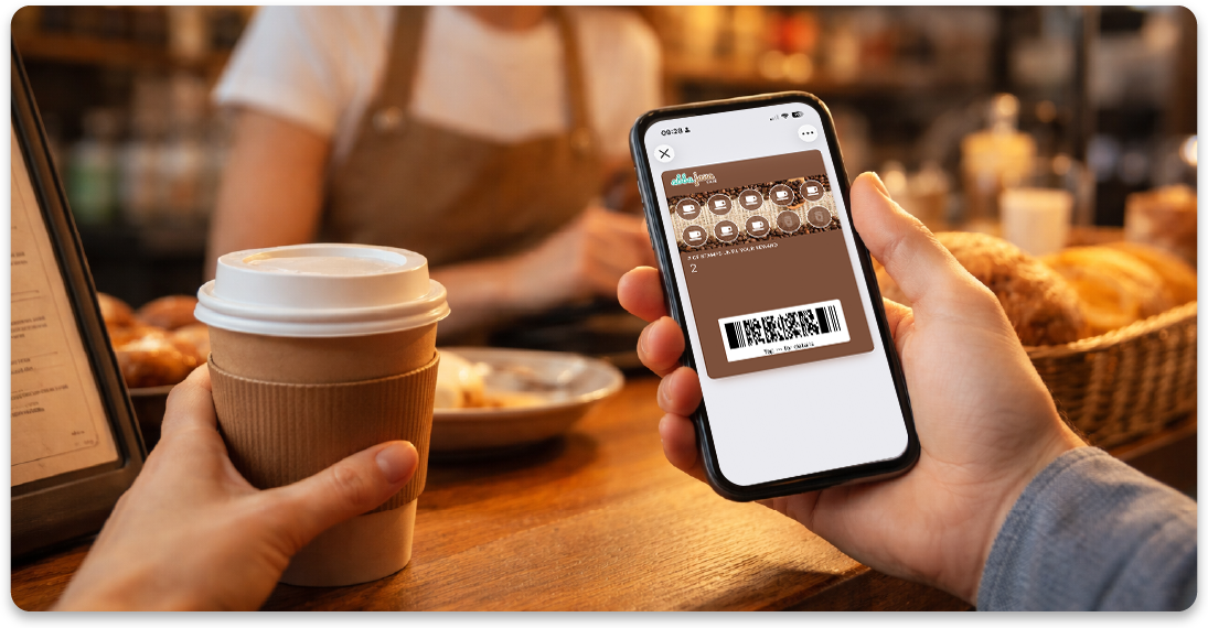 Customer holding a digital coffee shop loyalty card in Apple Wallet